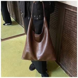Détail du sac cabas vintage marron foncé montrant la texture en similicuir et la bandoulière