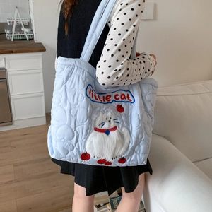 Detail of light blue quilted tote bag with cute 3D cat embroidery and heart pattern