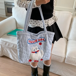 Detail of light blue quilted heart tote bag with embroidered white cat and little cat text