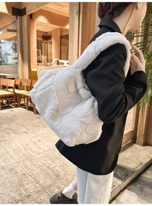Close-up detail of white fuzzy plush tote bag with textured faux fur and wide handles