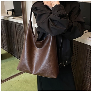 Détail d'un grand sac cabas marron foncé avec texture plissée rétro et chaîne en métal