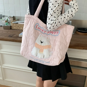 Detail of pink quilted tote bag with heart patterns and plush puppy embroidery