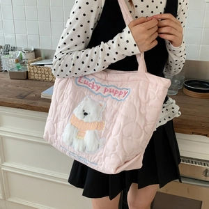 Detail of pink quilted tote bag featuring heart patterns and lucky puppy embroidery