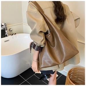 Sac fourre-tout rétro en cuir marron avec large bandoulière dans un décor style de vie