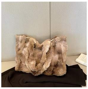 Détail d'un sac cabas en peluche marron montrant la texture douce et les anses solides