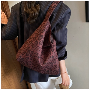 Detailed back view of a large leopard print tote bag styled with a dark navy blazer