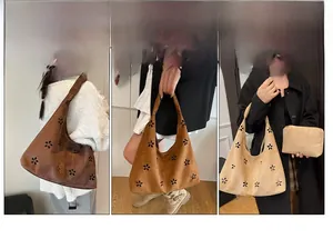 Detail view of hollowed floral pattern on suede tote bag in three different colors