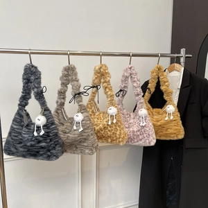 Variety of leopard print faux fur tote bags with cute charms hanging on shop rack