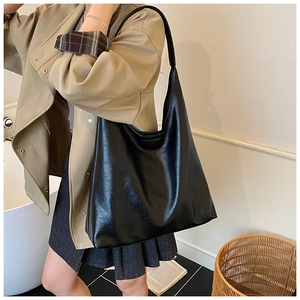 Gros plan d'un sac hobo en cuir brillant noir avec drapé naturel et grande capacité