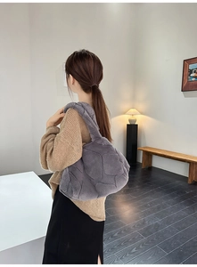 Detail of grey faux fur shoulder bag with geometric stitching on a female model