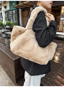 Detail of cream plush tote bag with circular quilting and gold metal hardware button