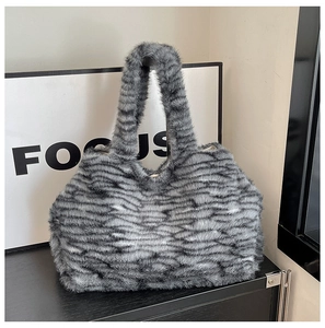 Texture dettagliata della borsa tote in ecopelliccia a righe grigie e nere con manico