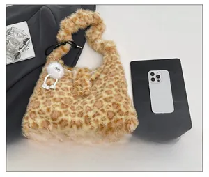 Detailed top view of leopard print plush tote bag with a cute white monster pendant accessory