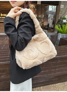 Detail of beige faux fur tote bag with circular quilted pattern shown on a shoulder