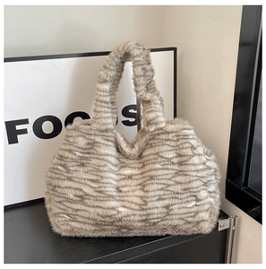 Dettaglio borsa tote in ecopelliccia con strisce grigie e morbida texture a mano