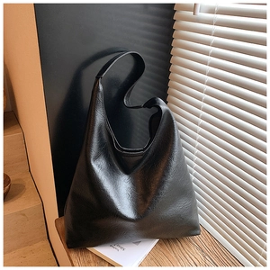 Détail d'un grand sac Hobo noir avec texture cuir premium et bandoulière élégante
