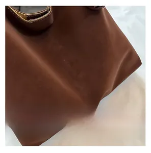 Close-up of the MIAO & SHE FASHION logo on dark brown frosted leather tote bag