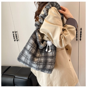 Vue détaillée du sac cabas en peluche à carreaux gris avec bandoulière à volants