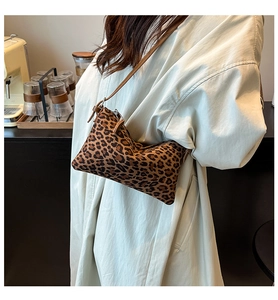 Close-up of leopard print baguette bag featuring soft texture and leather strap details