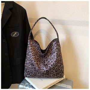 Detailed close-up of leopard print tote bag placed on books in a stylish scene