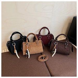 Détail de quatre sacs à main en daim avec boucles métalliques et perles en bois décoratives