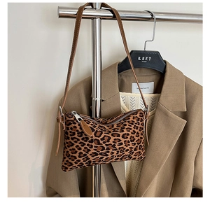 Detail of leopard print shoulder bag with brown strap and silver zipper on a hanger