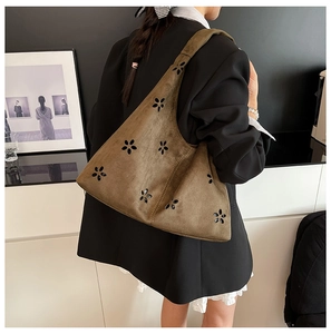 Detail view of khaki suede tote bag with hollow flower patterns and premium stitching