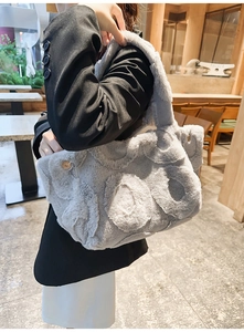 Detail of grey faux fur tote bag with embossed circular patterns and magnetic closure