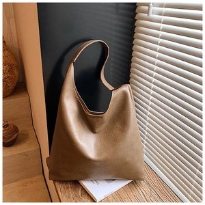 Détail d'un grand sac fourre-tout en cuir marron avec lumière et ombre sur bois