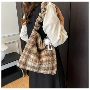 Détail du sac cabas en peluche à carreaux marron et blanc avec une bandoulière à volants chic