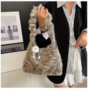 Detail of soft faux fur tote bag with zebra pattern and cute plush charm on shoulder