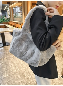 Close-up of grey faux fur tote bag featuring unique circular embossed texture and wide strap