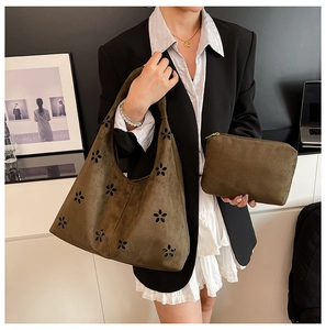 Olive green suede tote bag detail featuring floral laser cut-outs and matching inner pouch