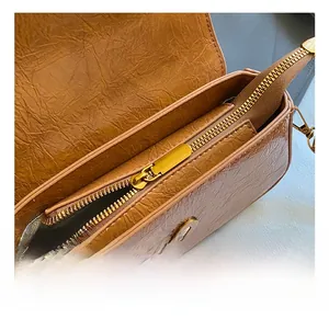 Detail shot of caramel brown pleated leather bag with high-quality gold metal zipper