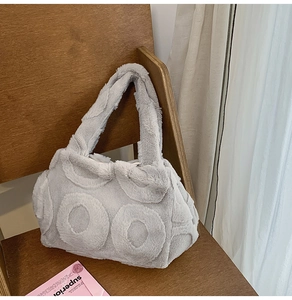 Close-up of light gray faux fur tote bag featuring a 3D circular geometric pattern