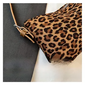 Detail shot of leopard print faux fur texture with leather strap and silver buckle