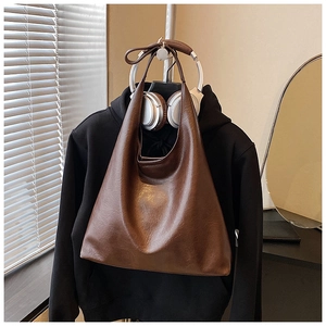 Détail de la texture en cuir marron du grand sac cabas suspendu avec style