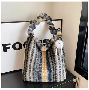 Gros plan d'un sac cabas en peluche aux rayures colorées avec une breloque mignonne