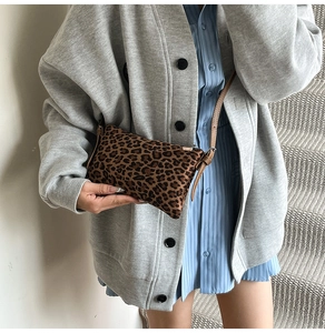 Detail of leopard print crossbody bag with thin leather strap and sleek zip closure