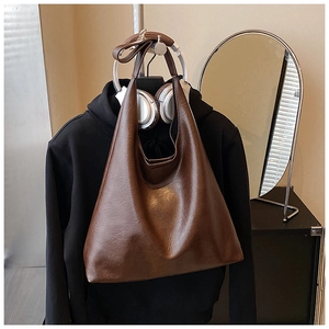 Détail du sac hobo marron foncé avec texture en cuir et design minimaliste à grande capacité