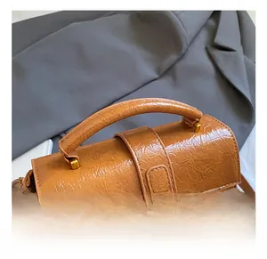 Detailed close-up of brown vintage texture faux leather handbag with gold metal hardware