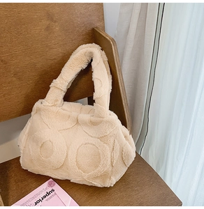 Detail of beige faux fur tote bag featuring unique embossed circular textured patterns