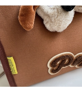 Détail du sac cabas en maille marron avec oreilles en peluche et broderie Snoopy