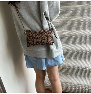 Detailed view of the leopard print crossbody bag with adjustable brown leather strap