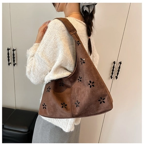 Detail of dark brown suede tote bag featuring a unique five-petal flower cutout design