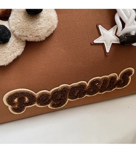 Vue macro de la broderie en peluche Pegasus et texture toile sur le sac fourre-tout