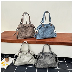 Detail showing vintage studded tote bags in four colors on a wooden bench and tile floor