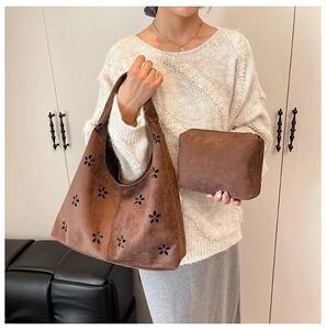 Detailed close-up of brown suede tote bag featuring intricate laser-cut floral patterns