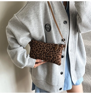 Lifestyle shot showing the leopard print crossbody bag worn with a casual grey cardigan