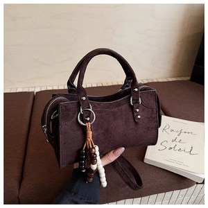 Détails macro du sac en daim marron foncé avec rivets vintage et breloques en bois